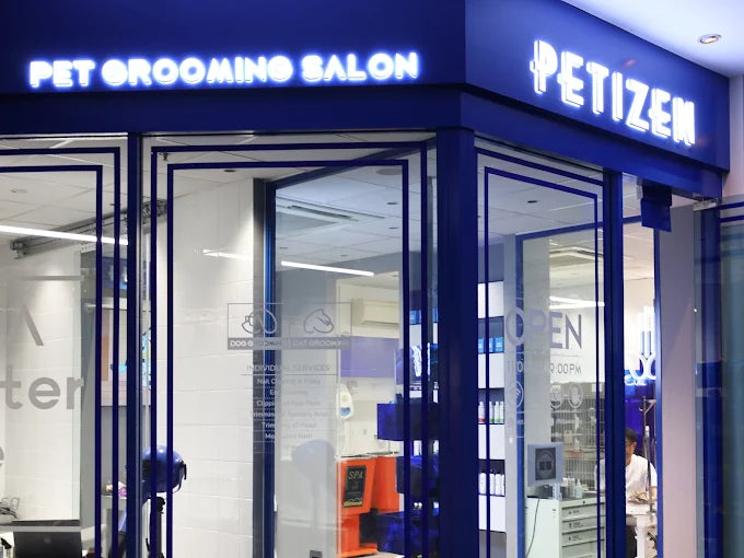 The lit Petizen Pet Grooming Salon sign above the glass shopfront